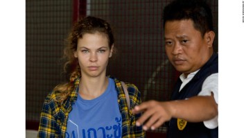 A police officer escorts Anastasia Vashukevich from a detention center in Pattaya, south of Bangkok, Thailand, Wednesday, Feb. 28, 2018, after she was arrested Sunday in the Thai resort city of Pattaya while giving sex lessons to Russian tourists. Vashukevich told The Associated Press from a police van Wednesday that she fears for her life, and wants to exchange information on alleged Russian ties to U.S. President Donald Trump???s campaign for her own personal safety. (AP Photo/Gemunu Amarasinghe)