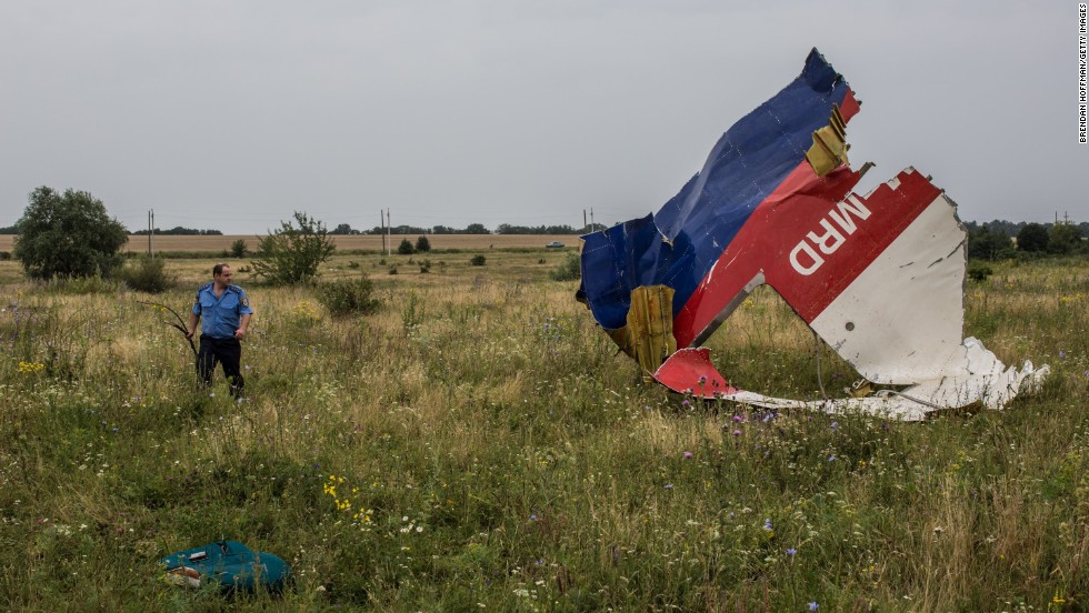 GRABOVKA, UKRAINE - JULY 18:  A Ukrainian police officer searches for human remains found in a field on July 18, 2014 in Grabovka, Ukraine. Air Malaysia flight MH17 travelling from Amsterdam to Kuala Lumpur crashed yesterday on the Ukraine/Russia border near the town of Shaktersk. The Boeing 777 was carrying 298 people including crew members, the majority of the passengers being Dutch nationals, believed to be at least 173, 44 Malaysians, 27 Australians, 12 Indonesians and 9 Britons. It has been speculated that the passenger aircraft was shot down by a surface to air missile by warring factions in the region.  (Photo by Brendan Hoffman/Getty Images)