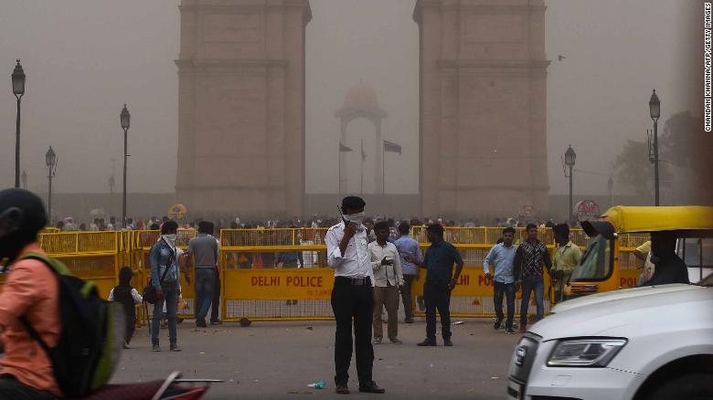 Un policía de tráfico indio se cubre la cara mientras se encuentra de servicio durante una tormenta de polvo en Nueva Delhi el 2 de mayo. (Crédito: CHANDAN KHANNA/AFP/Getty Images)
