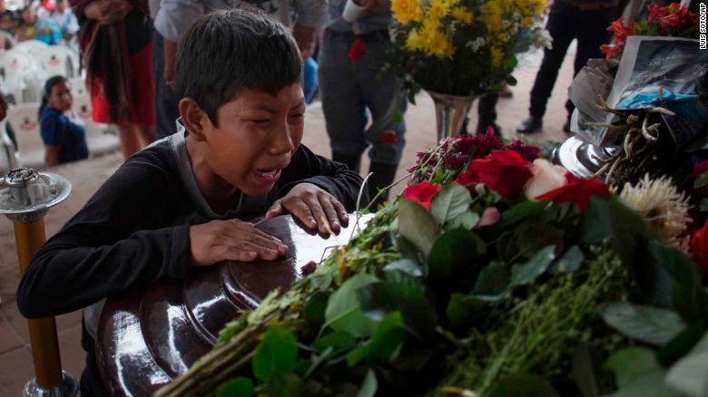 A youth cries over the coffin of Nery Otoniel Gomez Rivas, 17, whose body was pulled from the volcanic ash during the eruption of the Volcan de Fuego, which in Spanish means Volcano of Fire, during his wake at the main park of the town San Juan Alotenango, Guatemala, Monday, June 4, 2018. A fiery volcanic eruption in south-central Guatemala sent lava flowing into rural communities, killing dozens as rescuers struggled to reach people where homes and roads were charred and blanketed with ash. (AP Photo/Luis Soto)