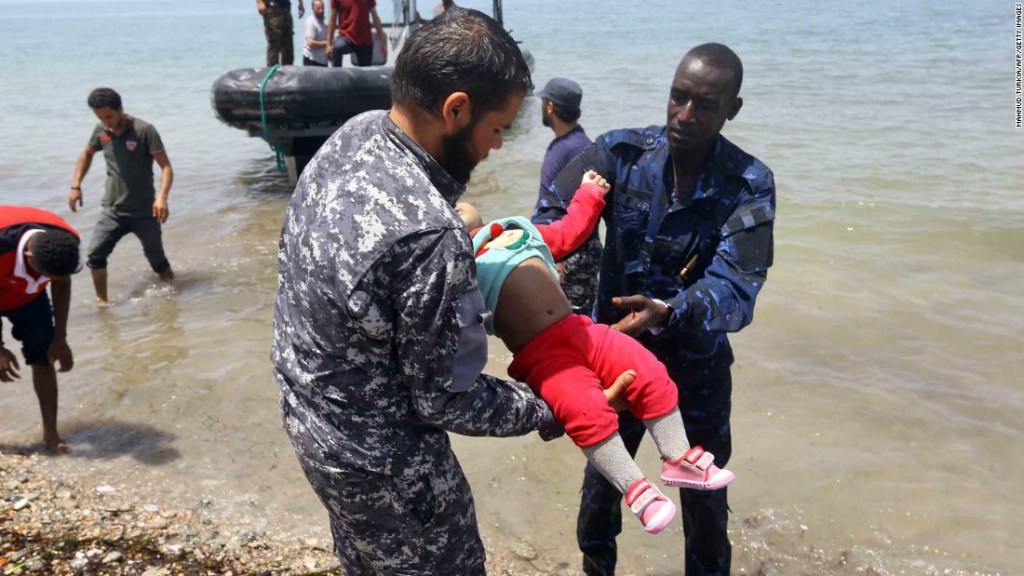 Sobrevivientes llegan a la costa mientras dos hombres toman a otro de los bebés. (Crédito: MAHMUD TURKIA/AFP/Getty Images)
