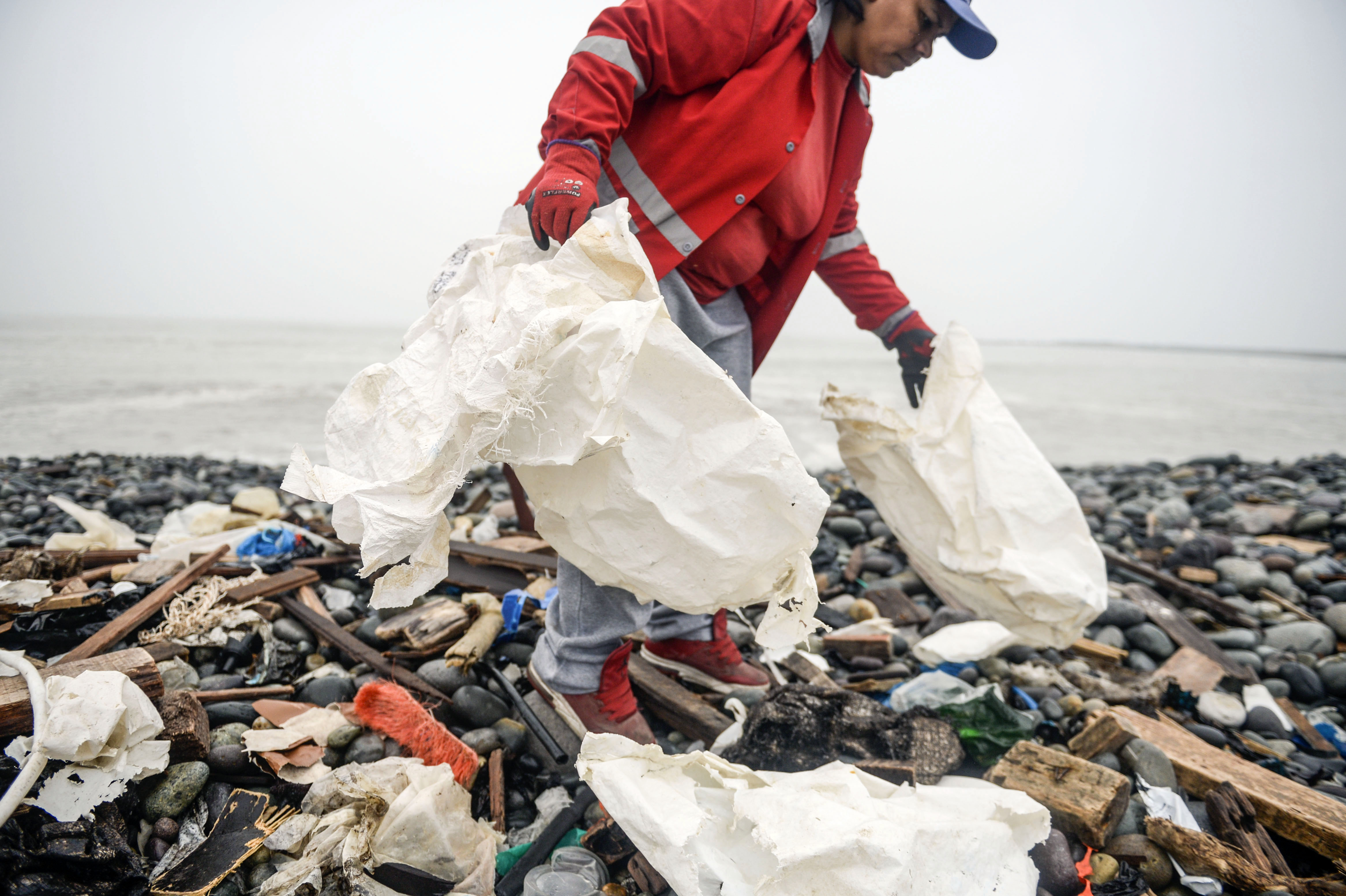 Voluntarios recogen restos de bolsas de plástico en la playa de Lima, Perú, con motivo del Día del Medio Ambiente, este 5 de junio de 2018. (Crédito: ERNESTO BENAVIDES/AFP/Getty Images)