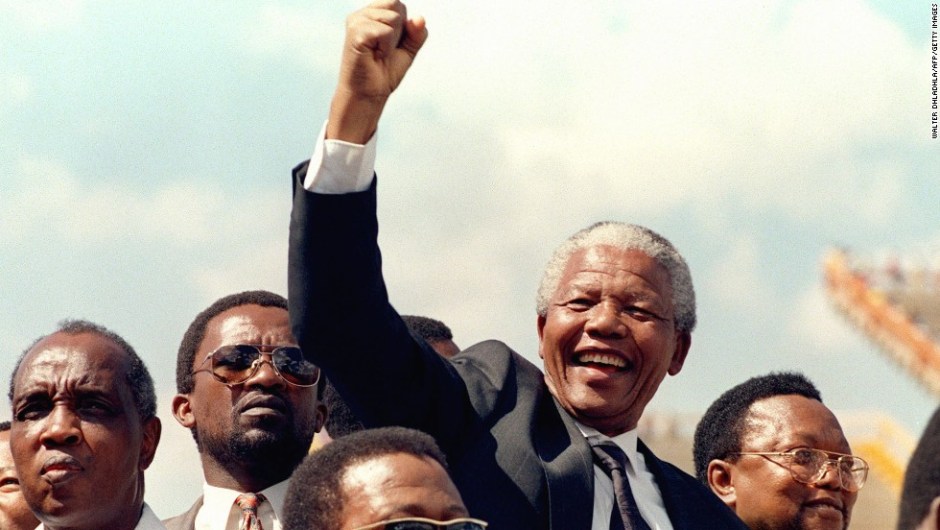 MMABATHO, SOUTH AFRICA: South African National Congress (ANC) President Nelson Mandela gives 15 March 1994 in Mmabatho a clenched fist to supporters upon his arrival for his first election rally for 27 April general elections. (Photo credit should read WALTER DHLADHLA/AFP/Getty Images)