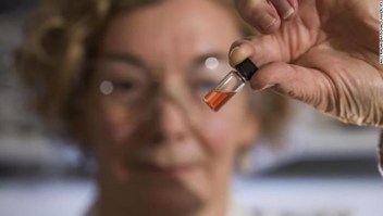 La gerente de laboratorio de biogeoquímica de ANU, Janet Hope, sostiene un vial que contiene los pigmentos intactos más antiguos del mundo.