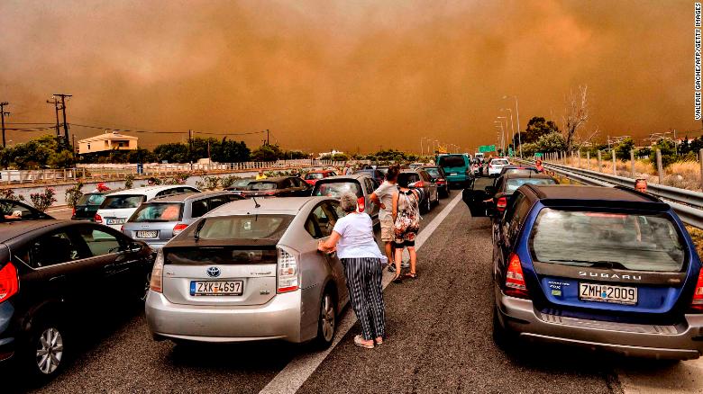 Automóviles se quedan bloqueados en una carretera nacional cerrada durante el incendio forestal de Kineta el lunes. (Crédito: VALERIE GACHE/AFP/Getty Images)