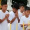Chanin Vibulrungruang light a candle with members of the rescued soccer team attend a Buddhist ceremony that is believed to extend the lives of its attendees as well as ridding them of dangers and misfortunes in Mae Sai district, Chiang Rai province, northern Thailand, Tuesday, July 24, 2018. Eleven of the boys and their coach rescued last week from the flooded Tham Luang cave attend a merit making ceremony at a buddhist temple. The boys are also expected to have their heads shaved in the afternoon in preparation for their ordination as buddhist novices. (AP Photo/Sakchai Lalit)