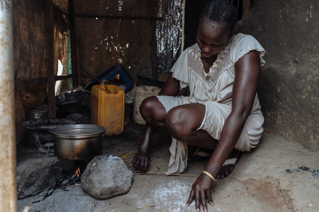 Angeline, una mujer de Sudán del Sur, fotografiada haciendo un fuego en su cocina. (Crédito: Hannah Reyes Morales)