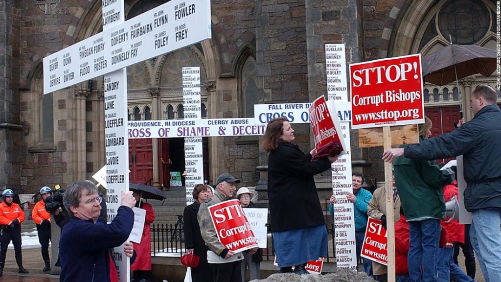 Terry McKiernan (izquierda) en una protesta de 2003 en Boston con una cruz con nombres de miembros del clero católicos acusados de abuso sexual. (David L Ryan/The Boston Globe via Getty Images)