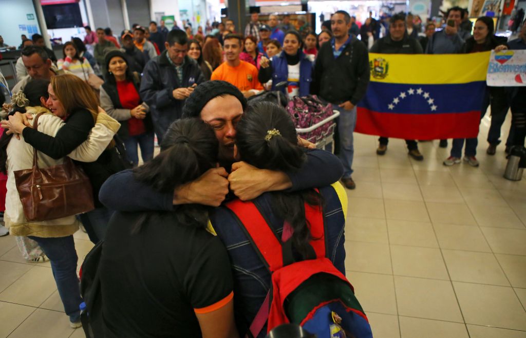 Venezuelan migrants are embraced by relatives upon their arrival at the bus terminal in the north of Lima, after traveling for 20 hours from Tumbes, northwestern Peru, on August 26, 2018. - Venezuelan migrants denounced on Saturday that Ecuador "cheated" on them and delayed their transfer by road to Peru, which prevented them from crossing to that country before the passport requirement began to apply. (Photo by Teo BIZCA / AFP) (Photo credit should read TEO BIZCA/AFP/Getty Images)