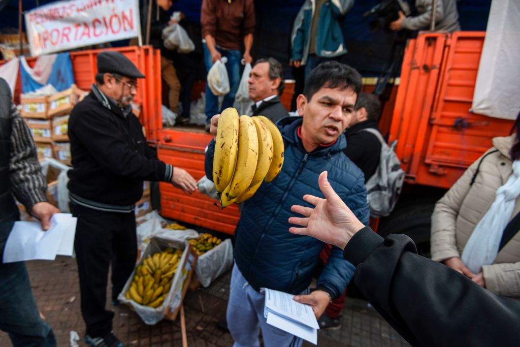 Producers give bananas for free during a protest at Plaza de Mayo square near the Casa Rosada presidential palace in Buenos Aires, on August 2, 2017. Banana producers gave away 30 tons of the fruit in demand of government assistance to try to reverse the complicated scenario that the domestic market is facing due to the importation of products at a very low price. / AFP PHOTO / Eitan ABRAMOVICH (Photo credit should read EITAN ABRAMOVICH/AFP/Getty Images)