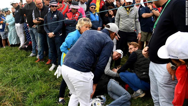 El golfista estadounidense Brooks Koepka asiste a un espectador lesionado en la Ryder Cup cerca de París.