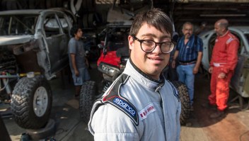 smiles at a mechanics workshop in Lima, on December 18, 2018, where his car is being prepared to take part in the upcoming Rally Dakar on January 2019. - Lucas Barron will make history on January 6 when he lines up on the Dakar 2019 start line in Peru, the first person with Down Syndrome to take part in the gruelling race. The 25-year-old, who will be co-pilot for his father Jacques, will tackle the world's most demanding rally: a 5,000 kilometer (3,000 miles), 10-day marathon, 70 percent of which will be raced over sand. (Photo by ERNESTO BENAVIDES / AFP) (Photo credit should read ERNESTO BENAVIDES/AFP/Getty Images)