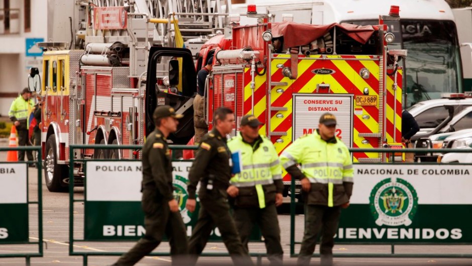 Police officers stand guard next to a firetruck at General Santander Police Academy in Bogota, a day after a car bomb attack killed 21 people and injured more than 80, on January 18, 2019. - Defense Minister Guillermo Botero described the Thursday bombing as "a terrorist attack committed by the ELN" and said he had "full evidence" that the bomber -- earlier identified as Jose Aldemar Rojas Rodriguez, 56 -- has been a member of the ELN for more than 25 years. (Photo by DANIEL MUNOZ / AFP) (Photo credit should read DANIEL MUNOZ/AFP/Getty Images)
