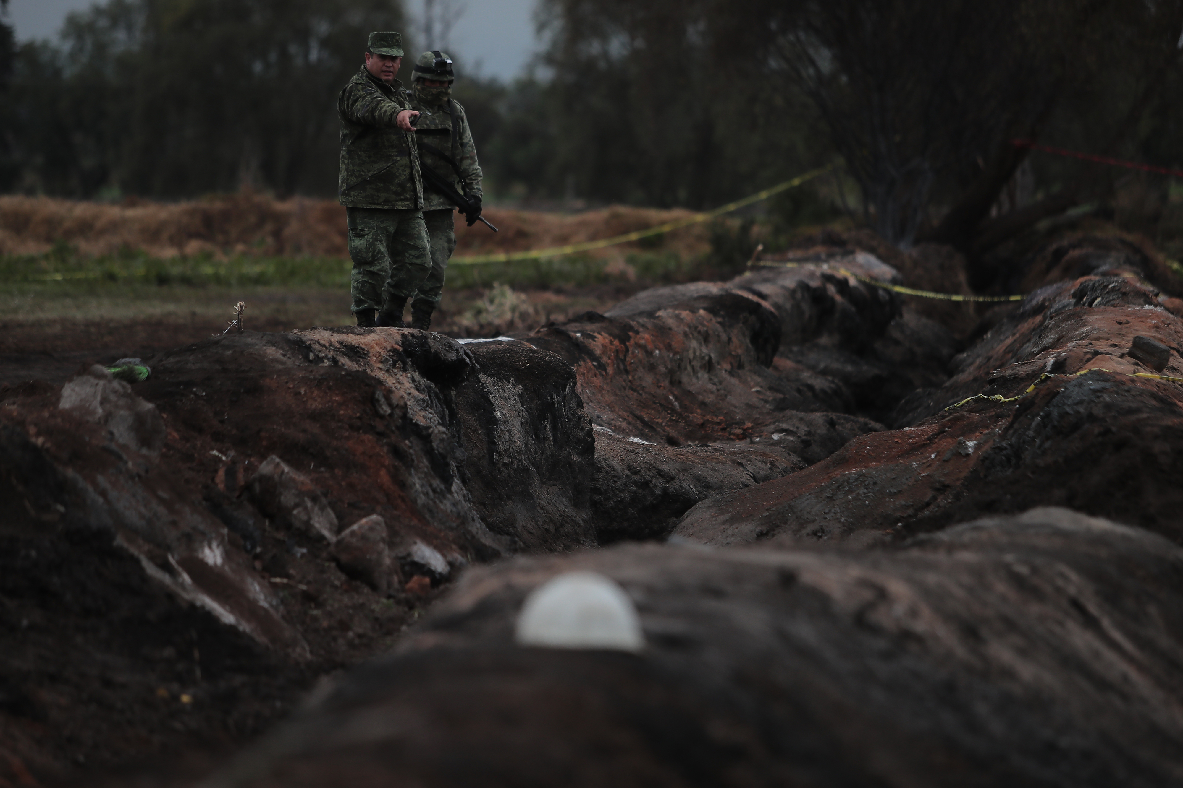 TLAHUELILPAN, MEXICO - JANUARY 20: Members of the Military watch over the explosion area of the pipeline on January 20, 2019 in Tlahuelilpan, Mexico. In a statement, PEMEX announced that the explosion was caused by the illegal manipulation of the pipeline, as minutes before the accident videos were shot where people could be seen filling drums and car fuel tanks. (Photo by Hector Vivas/Getty Images)