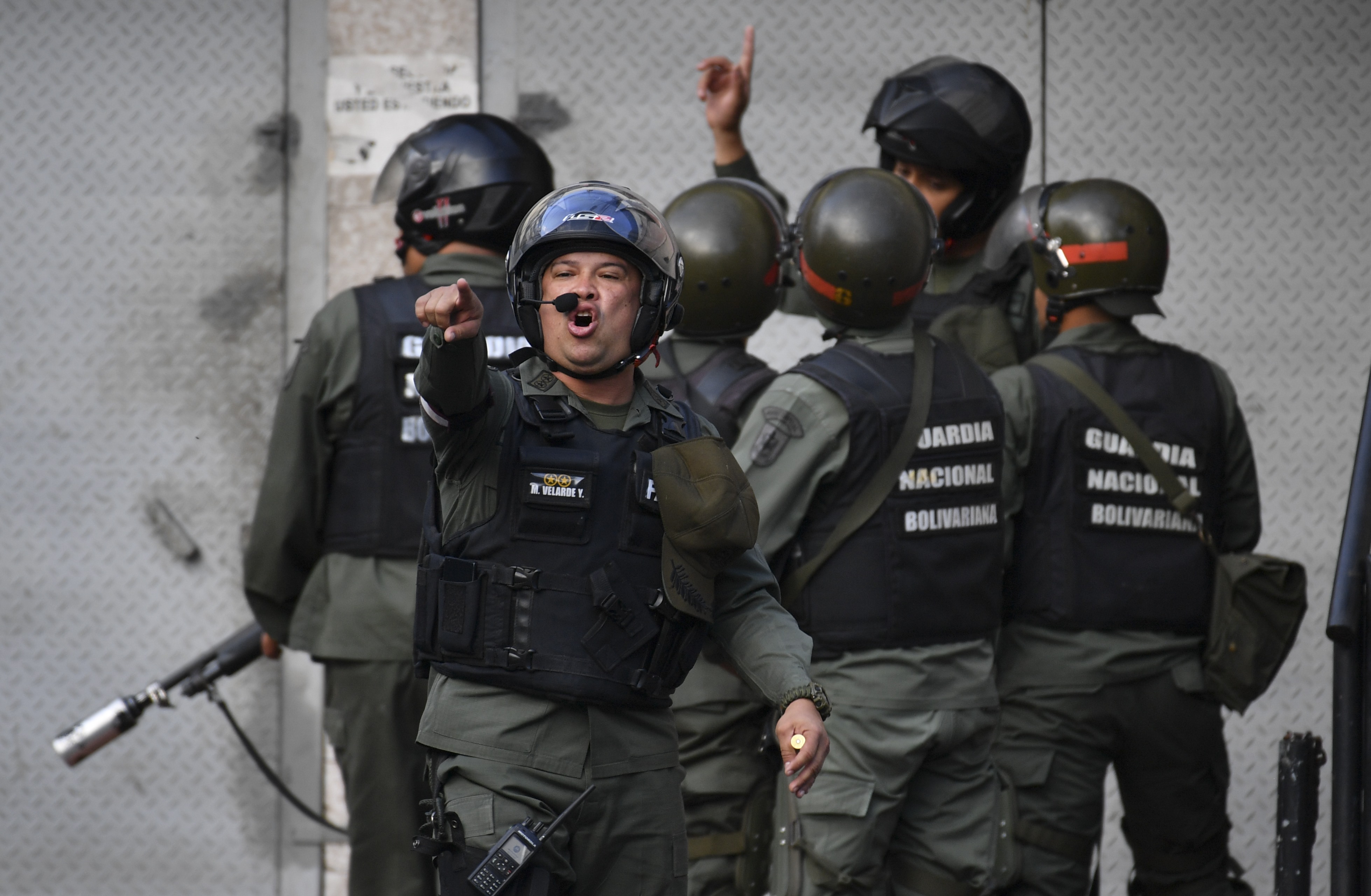 TOPSHOT - Members of the Bolivarian National Guard trough tear gas againts protesters near Cotiza Bolivarian National Guard headquarter in Caracas, Venezuela on January 21, 2019. - Venezuela military group calls in video for not recognizing Maduro (Photo by YURI CORTEZ / AFP) (Photo credit should read YURI CORTEZ/AFP/Getty Images)