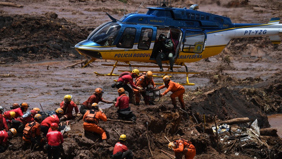 A helicopter provides support to the work of rescuers and firefighters in the search for victims, four days after the collapse of a dam at an iron-ore mine belonging to Brazil's giant mining company Vale near the town of Brumadinho, state of Minas Gerias, southeastern Brazil, on January 28, 2019. - The search for survivors intensified on Monday, on its fourth day, with the support of an Israeli contingent, after communities were devastated by a dam collapse that killed at least 60 people at a Brazilian mining complex -- with hopes fading for 292 still missing. A barrier at the site burst on Friday, spewing millions of tons of treacherous sludge and engulfing buildings, vehicles and roads. (Photo by Mauro Pimentel / AFP) (Photo credit should read MAURO PIMENTEL/AFP/Getty Images)
