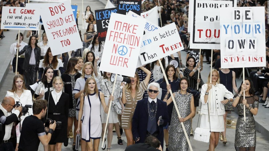 Lagerfeld, rodeado de modelos, camina por la pasarela después del desfile de Chanel Primavera-Verano 2015, con temática de protesta. Crédito: PATRICK KOVARIK/AFP/Getty Images