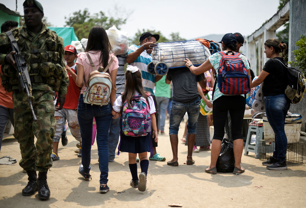 Venezuelan Leidy Navarro (L) walks with her daughter Valentina Caceres back to their home in Urena, Venezuela, after picking her up at school in Cucuta, Colombia, on March 6, 2019. - According to figures from the Secretary of Education of Cucuta, 9,174 Venezuelans study in schools in the capital of the department and, of them, about 3,000 cross the border every day. The crisis in Venezuela has also hit the educational system in the country, where dropout is high, there is a lack of teachers and schools buildings are suffering deterioration. (Photo by Juan Pablo BAYONA / AFP) (Photo credit should read JUAN PABLO BAYONA/AFP/Getty Images)