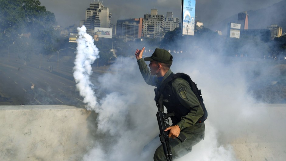 Un miembro de la Guardia Nacional Bolivariana que apoya a Juan Guaidó lanza un bote de gas lacrimógeno durante un enfrentamiento con guardias leales al gobierno del presidente Nicolás Maduro frente a la base militar de La Carlota en Caracas el 30 de abril de 2019. Crédito: YURI CORTEZ / AFP / Getty Images