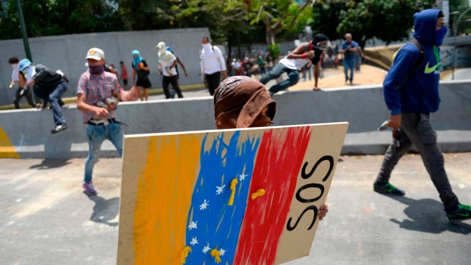 Anti-government protesters carry a shield and Molotov cocktails as thousands of other opposition demonstrators march in Caracas to commemorate May Day on May 1, 2019 after a day of violent clashes on the streets of the capital spurred by Venezuela's opposition leader Juan Guaido's call on the military to rise up against President Nicolas Maduro. - Guaido called for a massive May Day protest to increase the pressure on President Maduro. (Photo by Matias Delacroix / AFP) (Photo credit should read MATIAS DELACROIX/AFP/Getty Images)