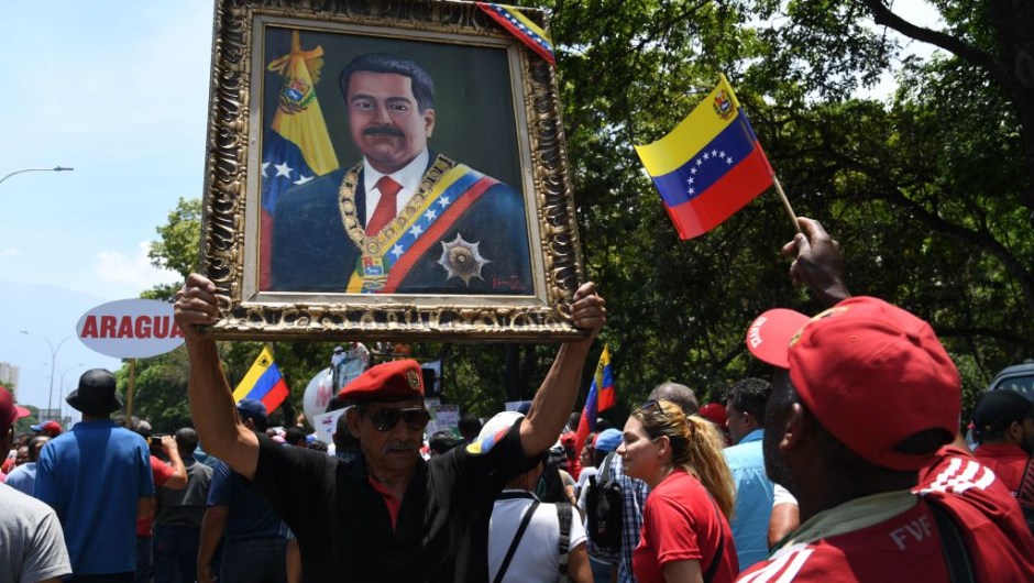 A supporter of President Nicolas Maduro display a painting of the Venezuelan leader during a rally on May Day in Caracas on May 1, 2019. - Pro- and anti-government rallies were due to take place in Venezuela, a day after violent clashes erupted in the capital following opposition leader Juan Guido's call on the military to rise up against Maduro, who claimed the insurrection had failed. (Photo by Yuri CORTEZ / AFP) (Photo credit should read YURI CORTEZ/AFP/Getty Images)