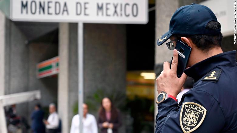 A policeman speaks on his mobile phone outside Mexico's Casa de Moneda, in Mexico City on August 6, 2019, which was robbed earlier today and the assailants took a swag of approximately two and a half million dollars in gold coins called "Centenarios". (Photo by ALFREDO ESTRELLA / AFP) (Photo credit should read ALFREDO ESTRELLA/AFP/Getty Images)