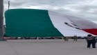 Civiles ayudan a militares con la bandera mexicana