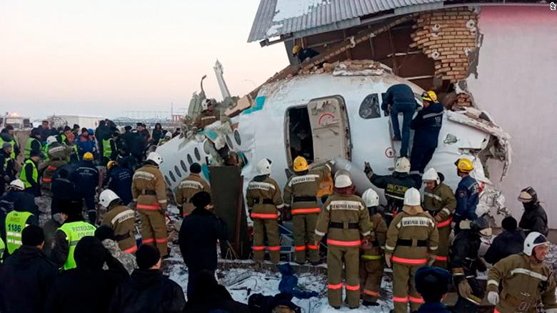 In this handout photo provided by the Emergency Situations Ministry of the Republic of Kazakhstan, police and rescuers work on the side of a plane crash near Almaty International Airport, outside Almaty, Kazakhstan, Friday, Dec. 27, 2019. Almaty International Airport said seven people died on Friday in the crash of a Bek Air plane in Kazakhstan. The aircraft had 100 passengers and crew abroad, and hit a concrete fence and a two-story building shortly after takeoff. ( Emergency Situations Ministry of the Republic of Kazakhstan photo via AP)