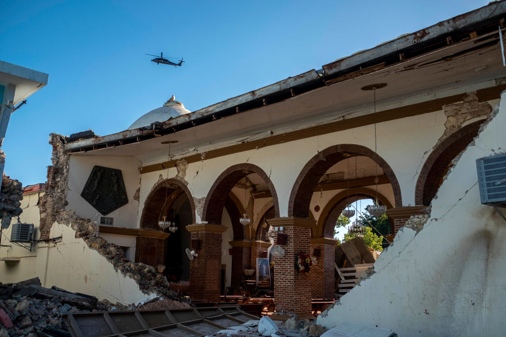 A helicopter flies over the Inmaculada Concepcion church, built in 1841, seen partially collapsed after an  earthquake hit the island in Guayanilla, Puerto Rico on January 7, 2020. - A strong earthquake struck south of Puerto Rico early January 7, 2020 followed by major aftershocks, the US Geological Survey said, the latest in a series of tremors that have shaken the island since December 28. The shallow 6.4 magnitude quake struck five miles (eight kilometers) south of the community of Indios, the USGS said, revising down its initial reading of 6.6. (Photo by Ricardo ARDUENGO / AFP) (Photo by RICARDO ARDUENGO/AFP via Getty Images)