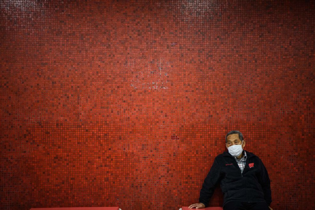 TOPSHOT - A man wearing a face mask sits on a bench as he waits on a platform for a MTR underground metro train during a Lunar New Year of the Rat public holiday in Hong Kong on January 27, 2020, as a preventative measure following a coronavirus outbreak which began in the Chinese city of Wuhan. (Photo by Anthony WALLACE / AFP) (Photo by ANTHONY WALLACE/AFP via Getty Images)