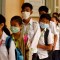 TOPSHOT - Mask-clad students line up to disinfect their hands with an alcohol solution before entering class at a school in Phnom Penh on January 28, 2020. - Cambodia's health ministry reported the country's first case of the deadly coronavirus on January 27. The virus, which can cause a pneumonia-like acute respiratory infection, has in a matter of weeks killed more 106 people and infected more than 4,000 in China, while cases have been identified in more than a dozen other countries. (Photo by TANG CHHIN Sothy / AFP) (Photo by TANG CHHIN SOTHY/AFP via Getty Images)