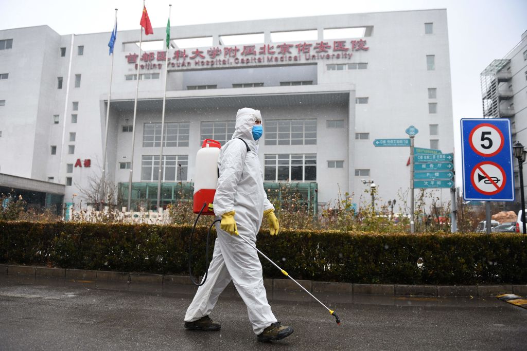 A worker sterilises a path at the Youan Hospital in Beijing on February 14, 2020. - Youan Hospital is one of twenty hospitals in Beijing treating coronavirus patients. Six health workers have died from the COVID-19 coronavirus in China and more than 1,700 have been infected, health officials said on February 14, underscoring the risks doctors and nurses have taken due to shortages of protective gear. (Photo by GREG BAKER / AFP) (Photo by GREG BAKER/AFP via Getty Images)