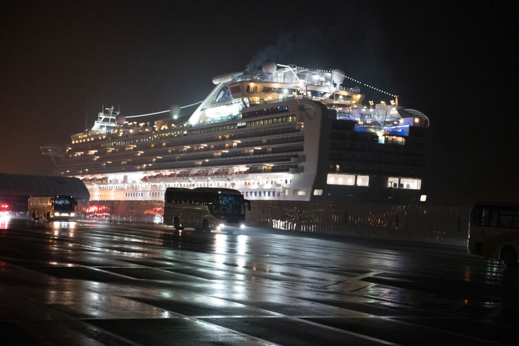 YOKOHAMA, JAPAN - FEBRUARY 17: Buses carry American citizens from the quarantined Diamond Princess cruise ship at Daikoku Pier to be repatriated to the United States, on February 17, 2020 in Yokohama, Japan. The United States has become the first country to offer to repatriate citizens on the Diamond Princess cruise ship while it remains quarantined in Yokohama Port as at least 355 passengers and crew onboard have tested positive for the coronavirus (COVID-19). Including cases onboard the ship, 408 people in Japan have now been diagnosed with COVID-19 making it the worst affected country outside of China. (Photo by Carl Court/Getty Images)