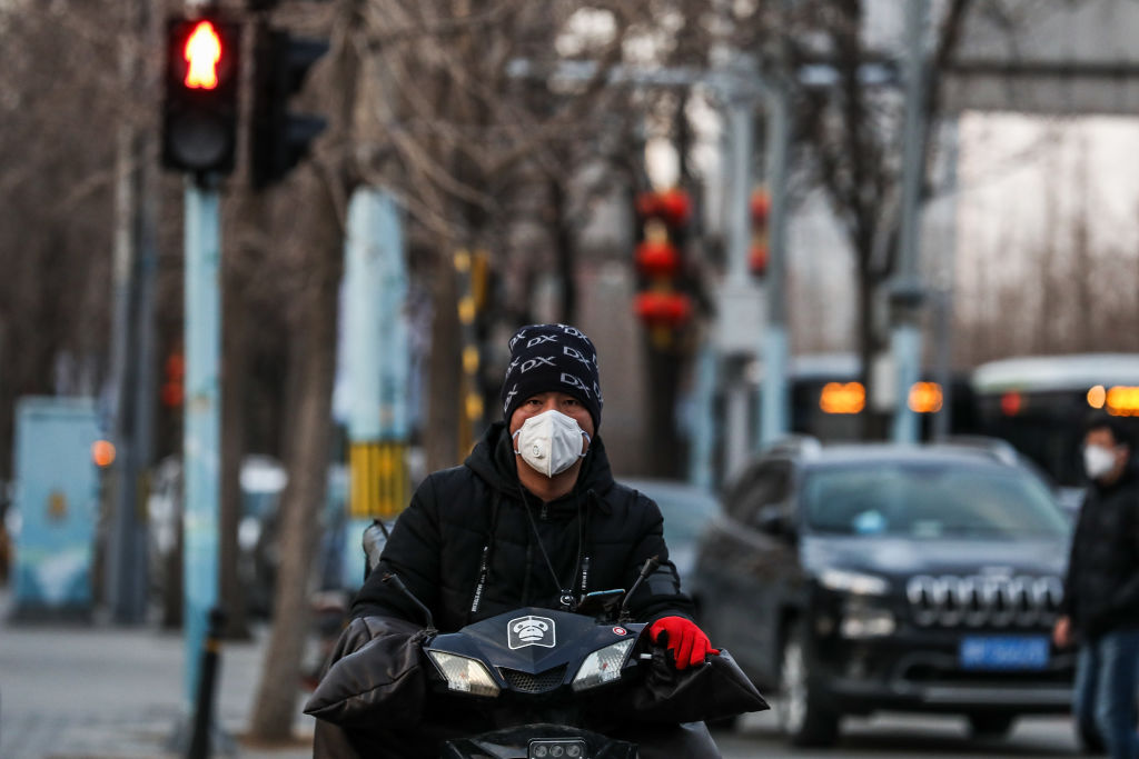 BEIJING, CHINA - FEBRUARY 19: A Chinese man wears a protective mask as he rides on the street on February 19, 2020 in Beijing, China. AsThe number of cases of a deadly new coronavirus has risen to more than 74,000 in mainland China, and as of today, 2,009 patients have died. (Photo by Lintao Zhang/Getty Images)