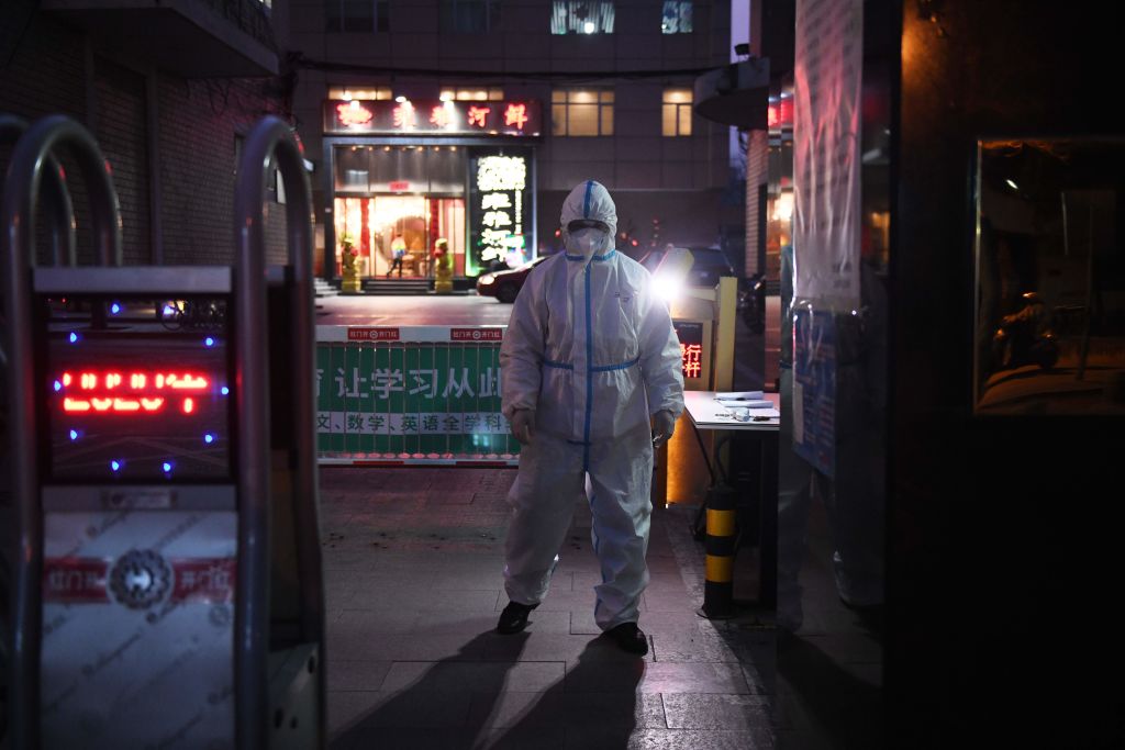 TOPSHOT - A security guard wears protective clothing as a preventive measure against the COVID-19 coronavirus as he stands at the entrance of a restaurant in Beijing on February 25, 2020. - China on February 25 reported another 71 deaths from the novel coronavirus, the lowest daily number of fatalities in over two weeks, which raised the toll to 2,663. (Photo by GREG BAKER / AFP) (Photo by GREG BAKER/AFP via Getty Images)