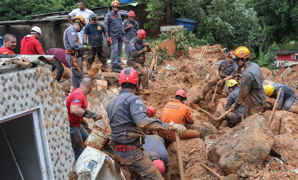 Rescuers search for victims at the Morro do Macaco Molhado favela in Guaruja, 95 km from Sao Paulo, on March 3, 2020 after torrential rains killed at least 15 people in Brazil. - At least 15 people have been killed in torrential rain that hit the Brazilian states of Sao Paulo and Rio de Janeiro, triggering flash floods and destroying houses, authorities said Tuesday. Violent storms in recent days have dumped a month's worth of rain on some areas in a matter of hours, devastating poor neighbourhoods on the southern coast of Sao Paulo state and on the outskirts of Rio de Janeiro, the country's second-biggest city. (Photo by GUILHERME DIONIZIO / AFP) (Photo by GUILHERME DIONIZIO/AFP via Getty Images)