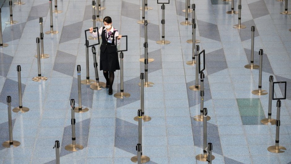 TOPSHOT - A facemask-clad airline employee works at the departure hall of Tokyo's Haneda Airport on March 10, 2020. - The death toll from the COVID-19 illness caused by the novel coronavirus neared 4,000, with more than 110,000 cases recorded in over 100 countries since the epidemic erupted in December in Wuhan, China. It has disrupted global travel, and cancelled conferences and sporting events. (Photo by Philip FONG / AFP) (Photo by PHILIP FONG/AFP via Getty Images)