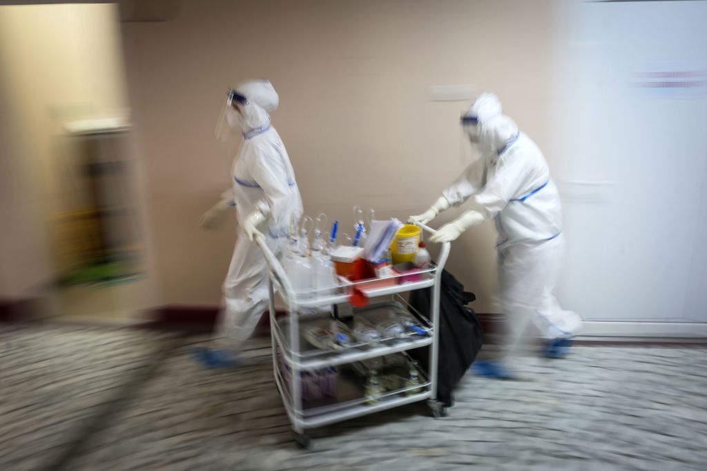 TOPSHOT - Medical workers bring medications to patients suffering from coronavirus disease (COVID-19) inside the Institute for Orthopaedic Surgery "Banjica", recently transformed to a COVID hospital, in Belgrade on July 14, 2020. - A candidate for the European Union, this small Balkan country is experiencing a resurgence of the pandemic, which has sparked several evenings of violent demonstrations to denounce the government's management of the health crisis. With 300 new cases now detected every day, Serbia is approaching April levels, at the peak of the first wave. (Photo by Oliver BUNIC / AFP) (Photo by OLIVER BUNIC/AFP via Getty Images)