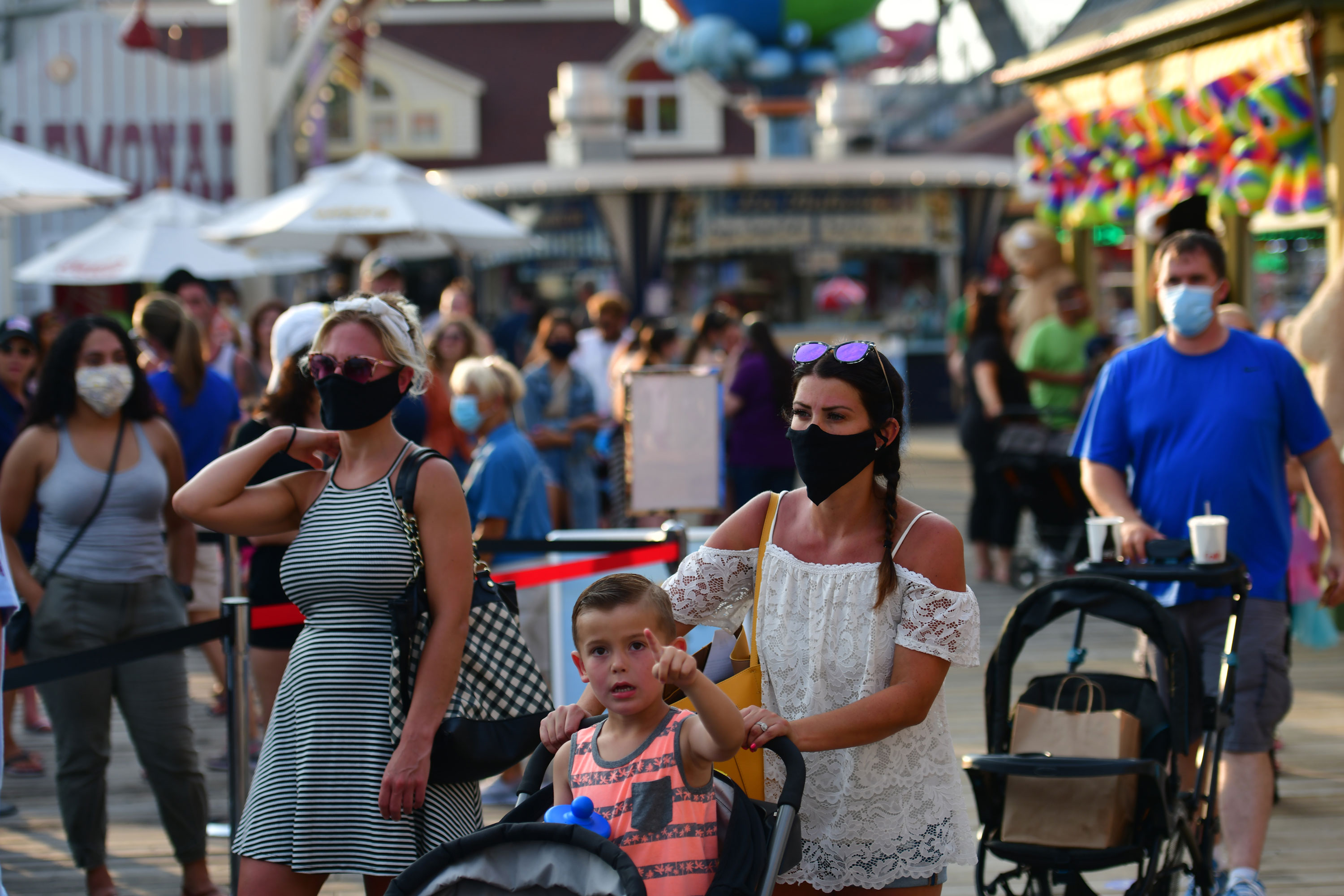 WILDWOOD, NJ - JULY 03: A family waits in line at the entrance to an amusement pier on July 3, 2020 in Wildwood, New Jersey. New Jersey beaches have reopened for the July 4th holiday as some coronavirus restrictions have been lifted, along with casinos, amusement rides and water parks at limited capacity. (Photo by Mark Makela/Getty Images)