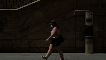 A woman wearing a face mask walks in Lerida (Lleida) on July 13, 2020. - A local court suspended a home confinement order imposed on more than 200,000 people in the Spanish region of Catalonia after an upsurge in virus cases. Catalonia officials ordered the home confinement on the city of Lerida and its surrounding areas a week after the zone had been placed under less strict lockdown. (Photo by Pau BARRENA / AFP) (Photo by PAU BARRENA/AFP via Getty Images)