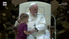 Niño se acerca al papa durante audiencia en el Vaticano